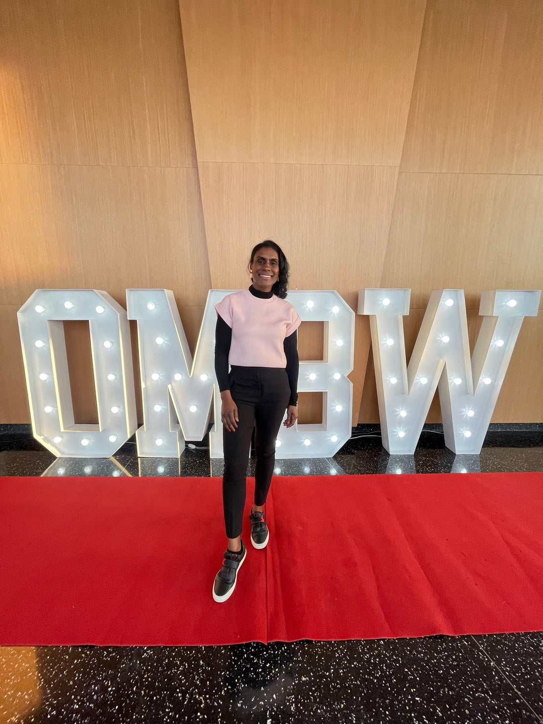 Image features a Black woman standing before a sign that reads "Black in Business Your Time is Now"